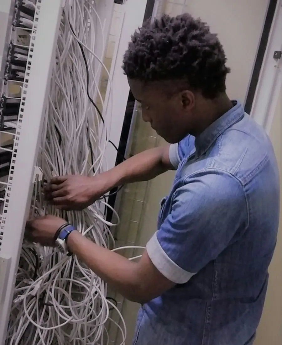 Technician organising cables in a network cabinet