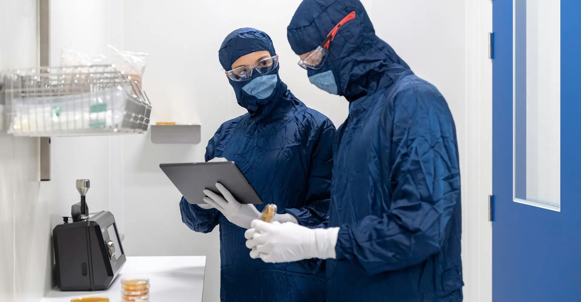 Two employees wearing masks and gloves in a cleanroom