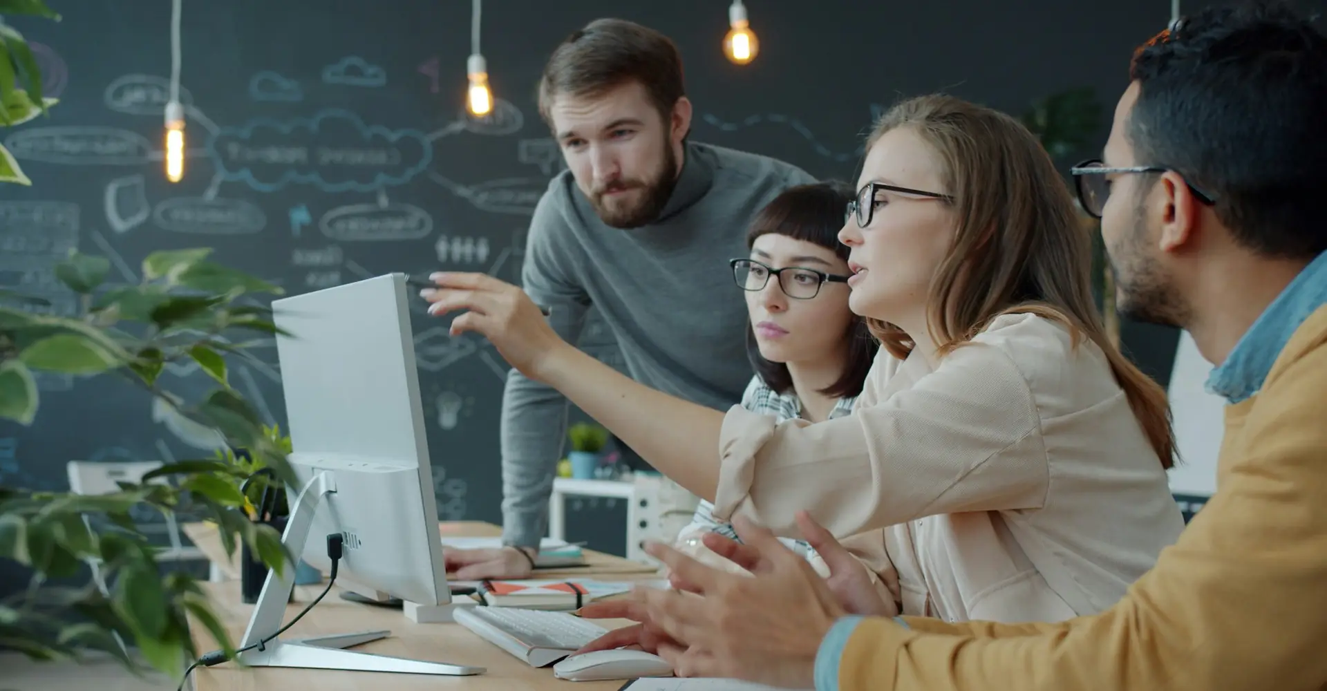 Team discussing an artificial intelligence solution in front of a computer