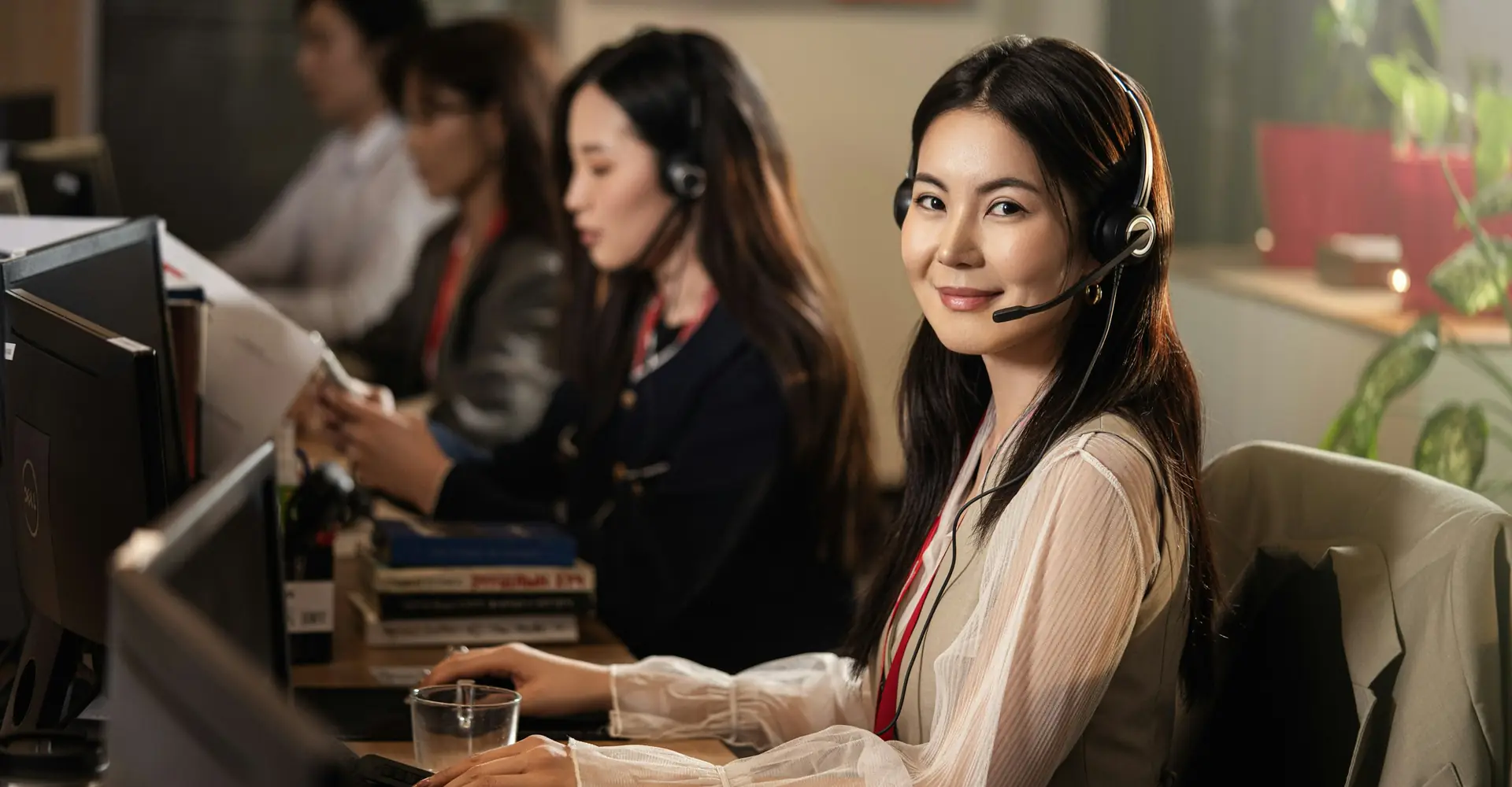 IT support employee wearing a headset in front of a computer